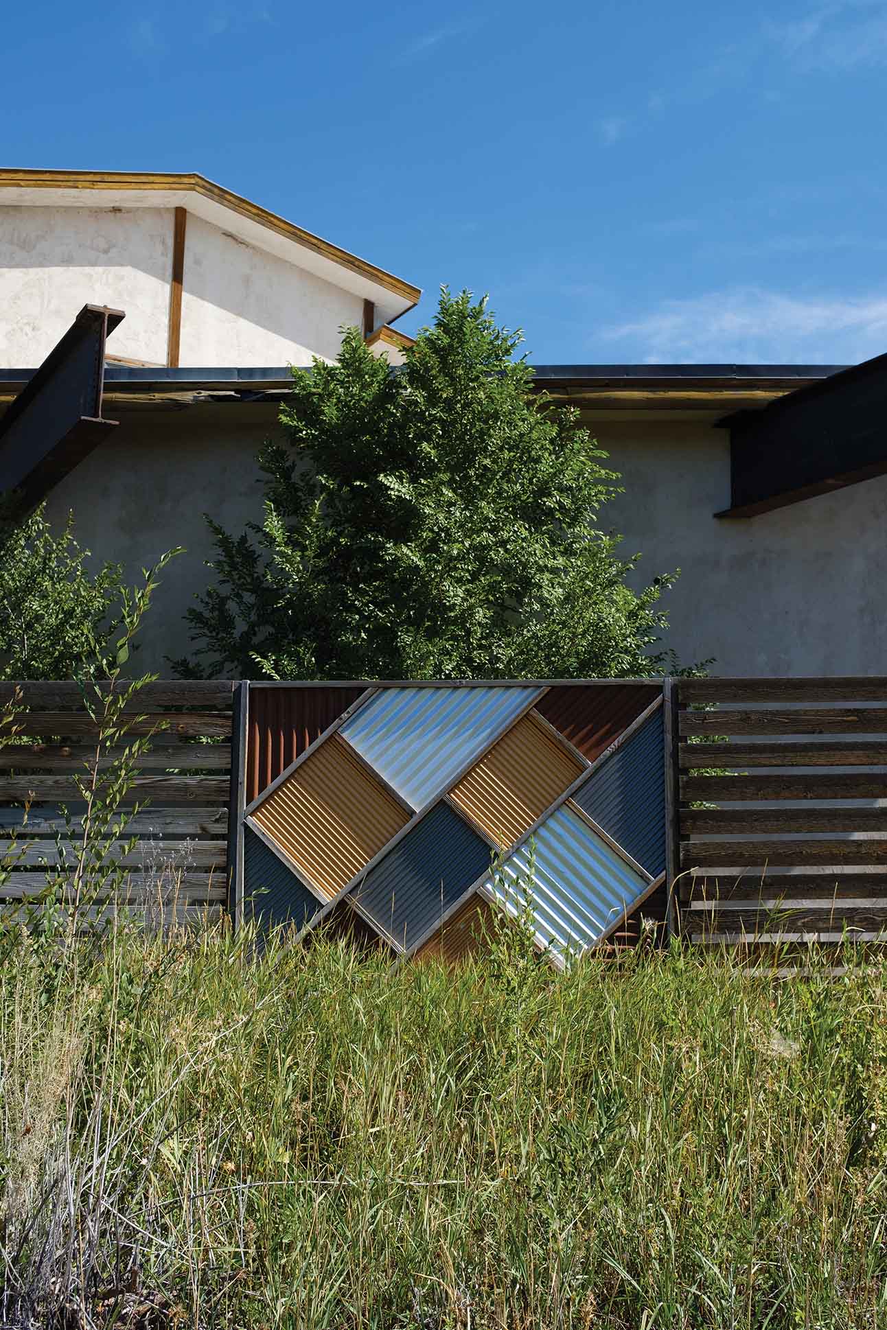 a fence with a metal panel in front of a building