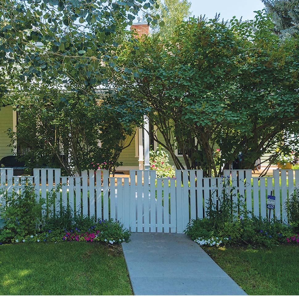 a white picket fence and walkway in front of a house