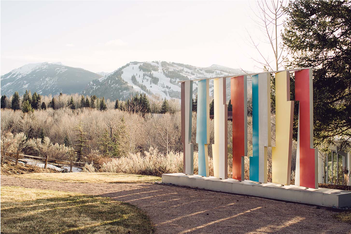 a colorful sculpture in front of a snowy mountain