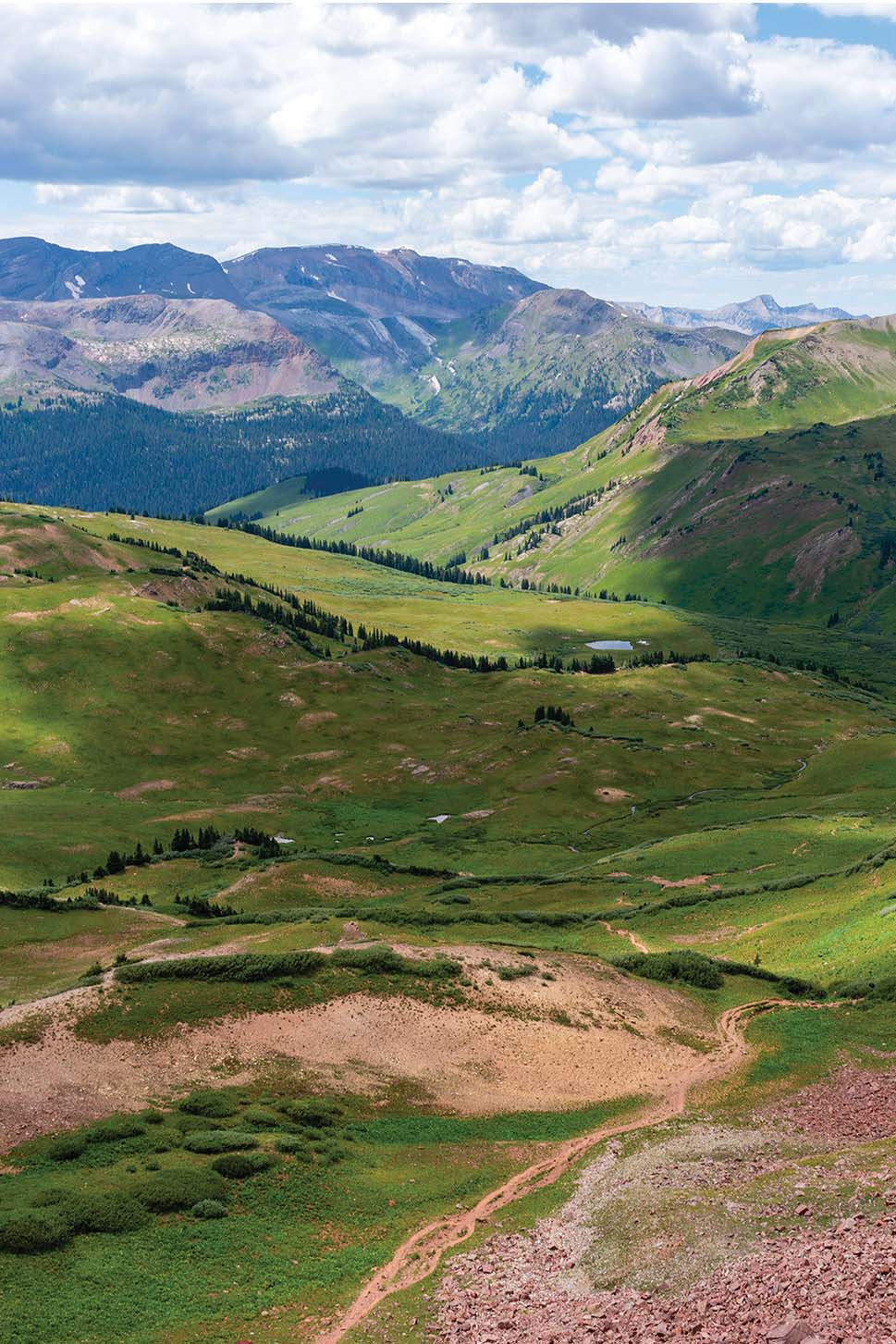 a green valley with mountains and trees