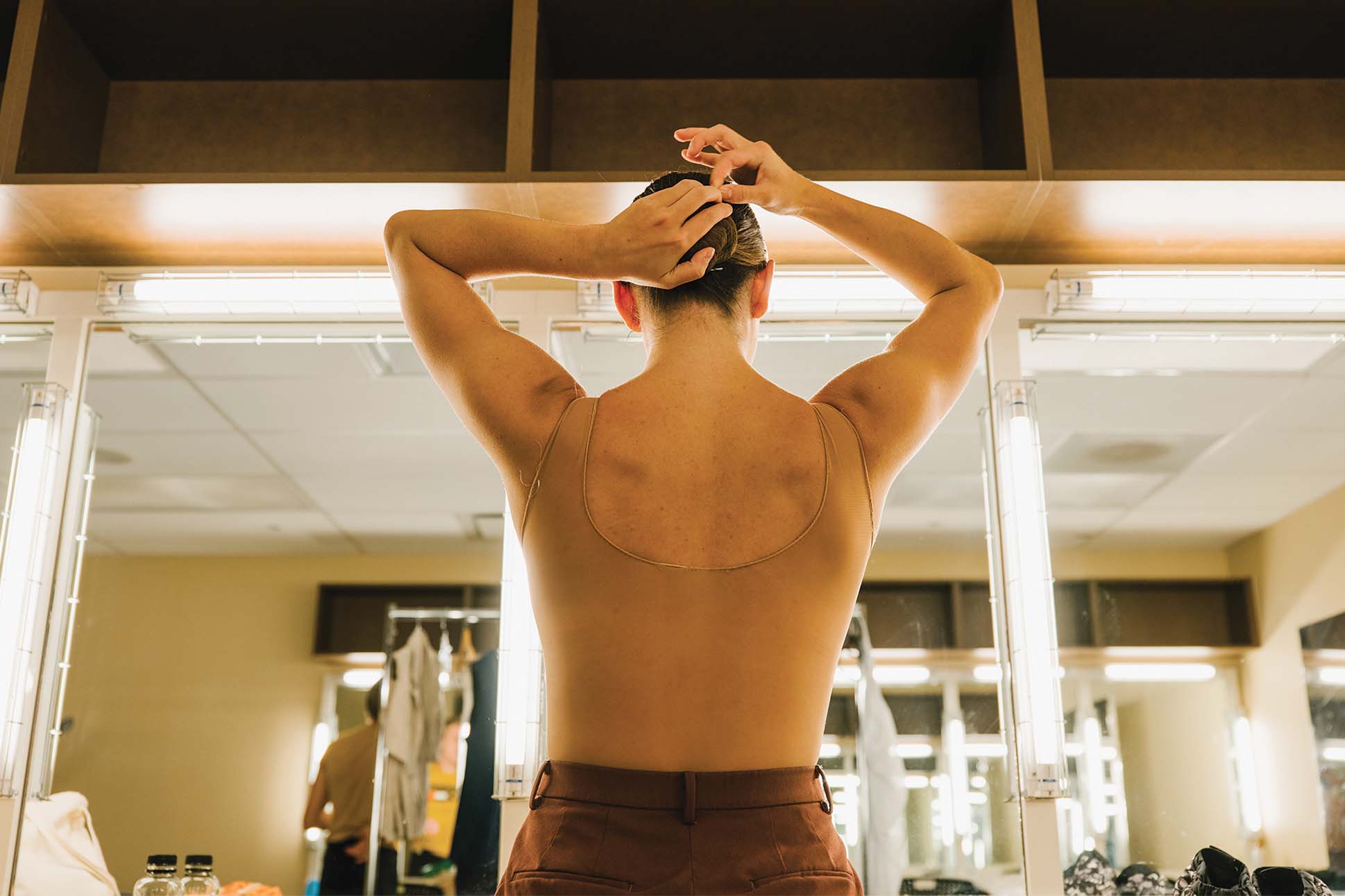 a person in a leotard preparing for a dance show