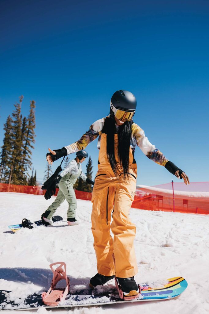 a person in a helmet and snow gear on a snowboard