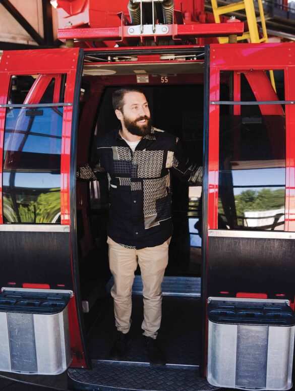 a person standing in the doorway of a red ski lift