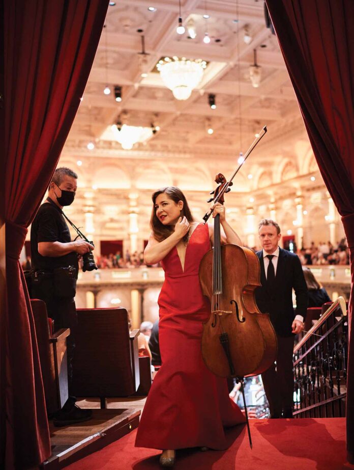 a person in a red dress holding a cello and a person in a mask