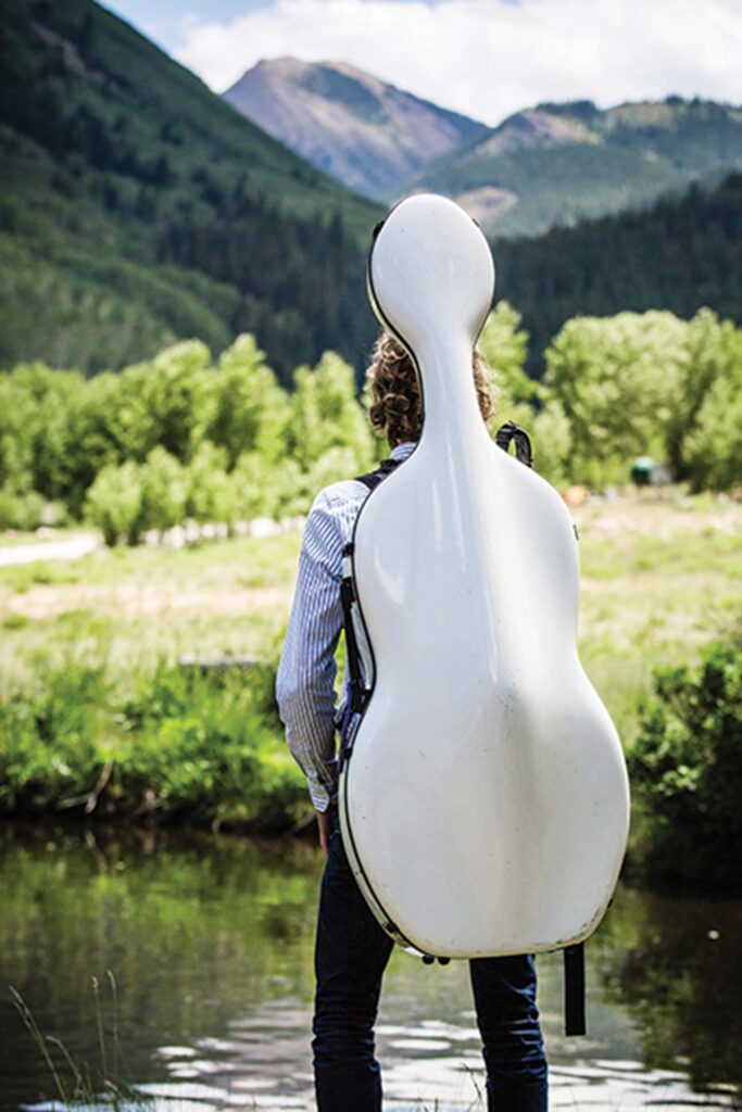 a person carrying a white cello case